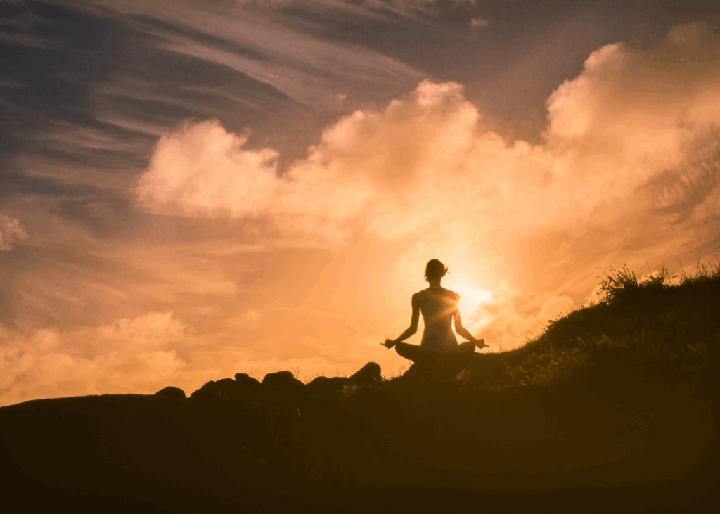woman on top of the mountain meditating with a shadowy hue